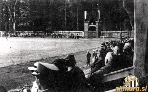 Pogled iz lesene tribune ob zahodnem robu igrišča proti južni strani, kjer je bil že tedaj glavni vhod na igrišče; fotografija je iz otvoritve stadiona, 28. junija 1936.